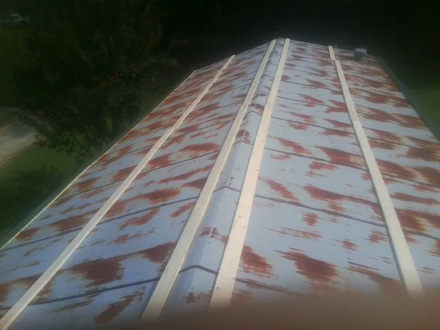Rusted metal roof panels with new wood purlins before replacement — Storm Damage Roof Repair in East Providence by Roofing Brothers