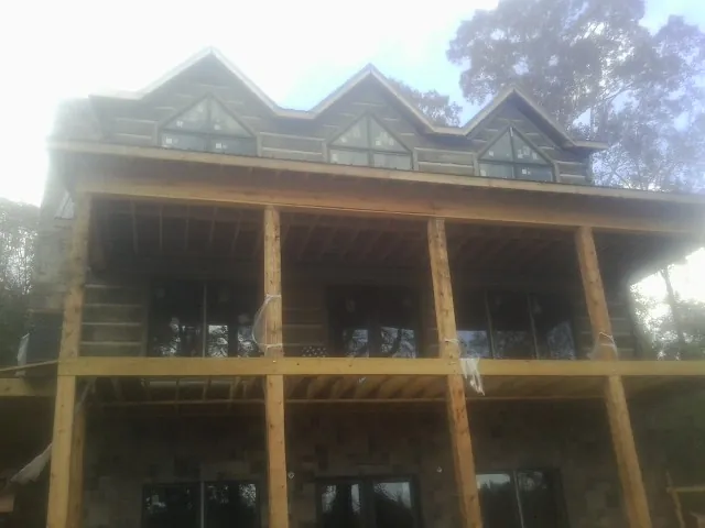 Dormers and porch framing on a large log home under construction — Roof Coating work by our crew in East Providence