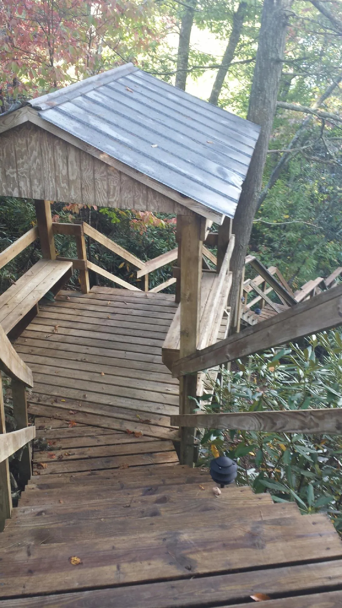 Metal roofed shelter over wooden steps on a wooded walkway — Skylight Repair & Installation work by our crew in East Providence